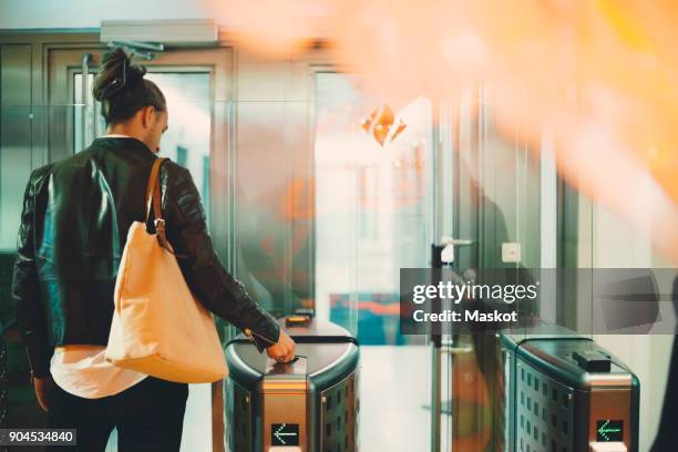 rear view of businessman using id card at turnstile in office - torniquete imagens e fotografias de stock