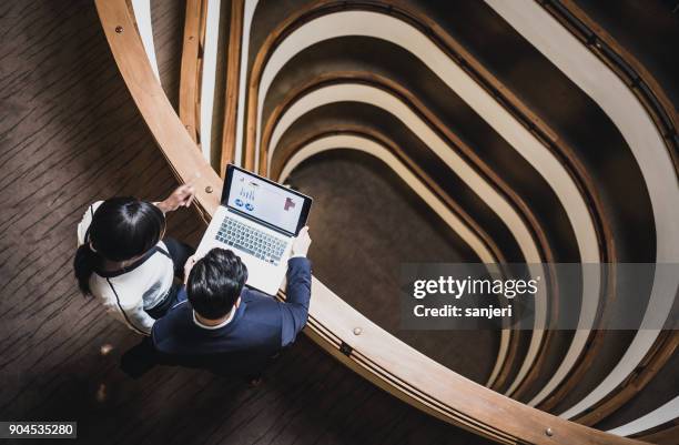 mensen uit het bedrijfsleven met een bijeenkomst op de gang - hoog standpunt stockfoto's en -beelden