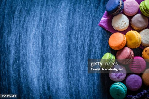 multi gekleurde bitterkoekjes schot van bovenaf op blauwe tafel - blue macarons stockfoto's en -beelden