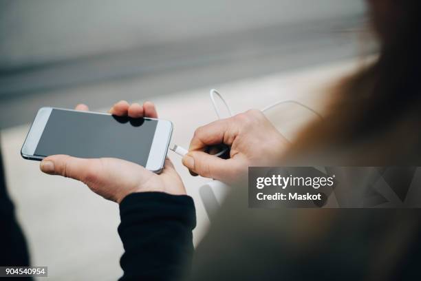 cropped image of mature businesswoman inserting usb cable in smart phone - charging phone stock pictures, royalty-free photos & images