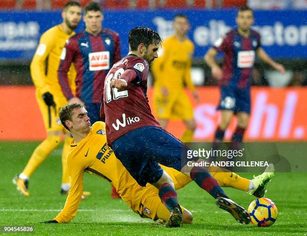 Atletico Madrid's French forward Antoine Griezmann vies with Eibar's Portuguese defender Paulo Oliveira during the Spanish league football match...