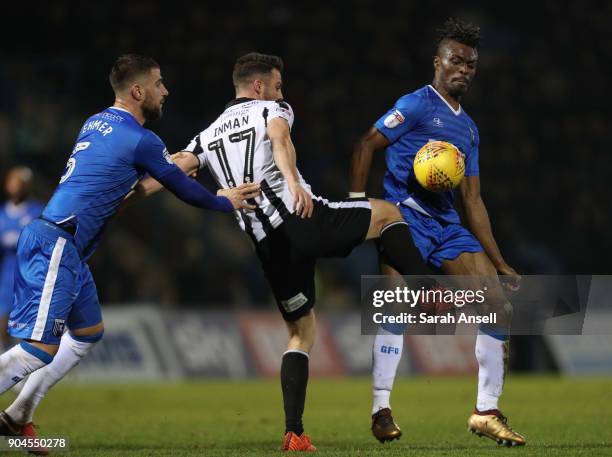 Max Ehmer and Gabriel Zakuani of Gillingham challenge Bradden Inman of Rochdale for the ball during the Sky Bet League One match between Gillingham...