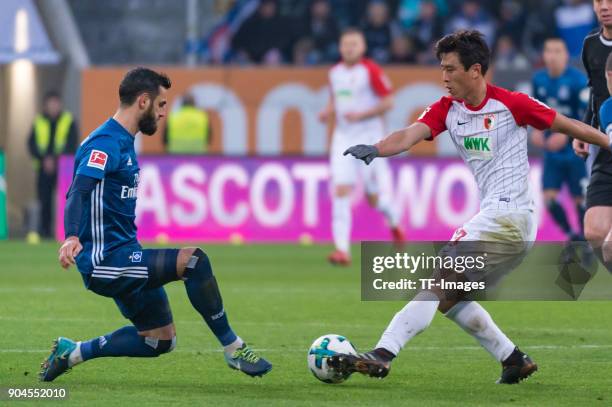 Mergim Mavraj of Hamburg and Ja-Cheol Koo of Augsburg battle for the ball during the Bundesliga match between FC Augsburg and Hamburger SV at...