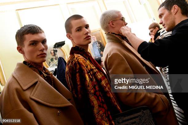 Models wait backstage before for fashion house Versace during the Men's Fall/Winter 2019 fashion shows in Milan, on January 13, 2018. / AFP PHOTO /...