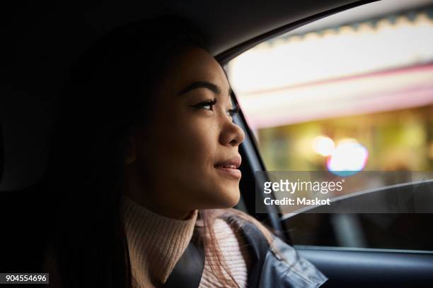thoughtful young woman looking through window while sitting in car - classic car point of view stockfoto's en -beelden