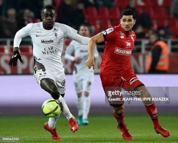 Metz' French defender Moussa Niakhate vies with Dijon's French-Algerian midfielder Mehdi Abeid during the French L1 football match Dijon vs Metz on...