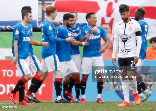 Camacho, the dejected captain of Brazilian club Corinthians walks away while players of Scottish club Rangers FC celebrate a second half goal during...