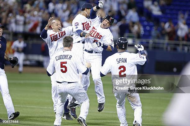 Orlando Cabrera , Alexi Casilla , Michael Cuddyer, and Denard Span join Jose Morales of the Minnesota Twins as he celebrates after he made the game...