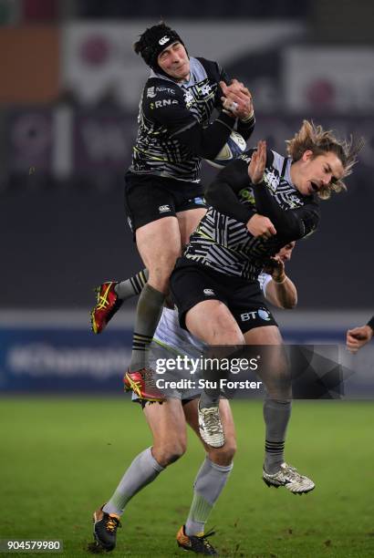 Ospreys player Sam Davies is tackled dangerously by Chris Wyles of Saracens as Jeff Hassler goes up for the ball during the European Rugby Champions...