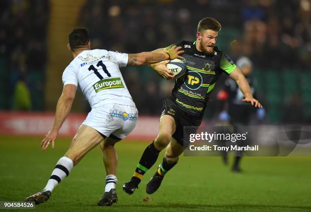 Rob Horne of Northampton Saints swerves from a tackle by Remi Grosso of ASM Clermont Auvergne during the European Rugby Champions Cup match between...