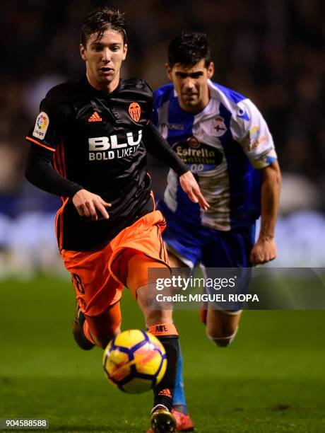 Valencia's Argentinian forward Luciano Vietto runs for the ball with Deportivo La Coruna's Spanish defender Juanfran Moreno during the Spanish league...