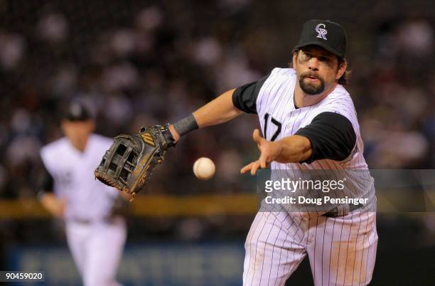 Firstbaseman Todd Helton of the Colorado Rockies tosses the ball to Jason Marquis, covering first base, to get a ground out on Matt Maloney of the...
