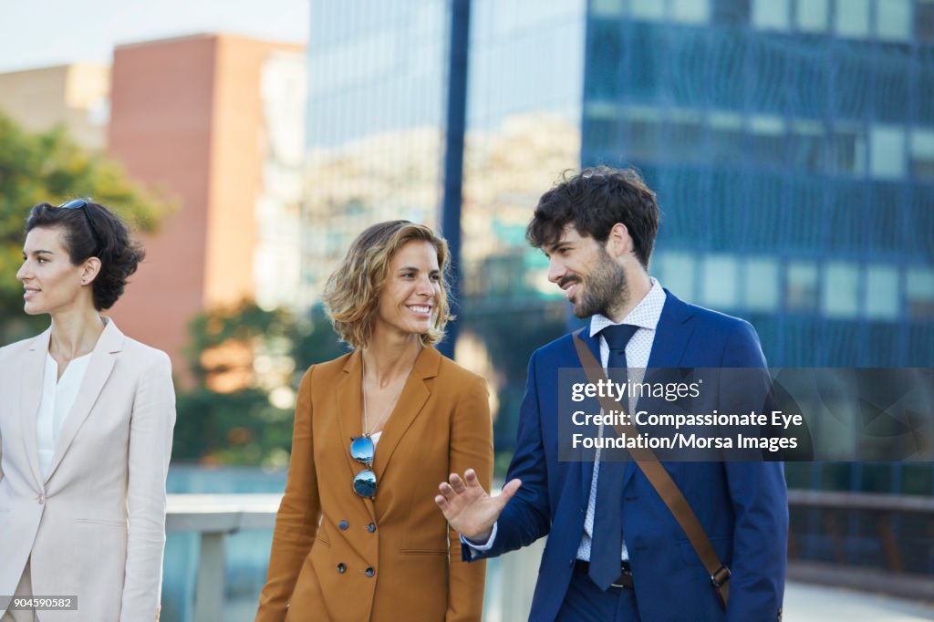 Business people walking and talking on city street