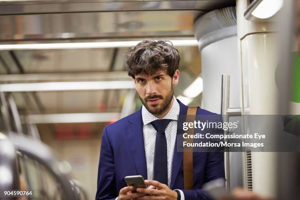 businessman texting on cell phone on subway train - underground train stock pictures, royalty-free photos & images