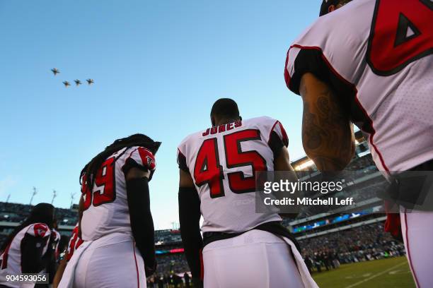 Middle linebacker Deion Jones and defensive end Adrian Clayborn of the Atlanta Falcons and teammates stand during a military flyover before taking on...