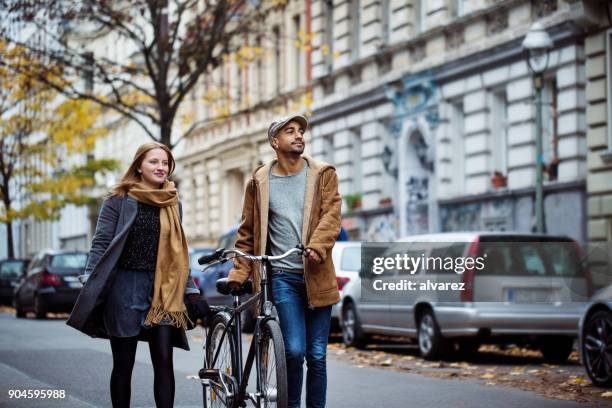冬の間に通りのサイクルで歩いている友人 - berlin people ストックフォトと画像