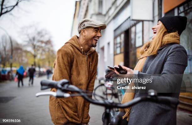 happy friends with bicycle talking in city - germany winter stock pictures, royalty-free photos & images