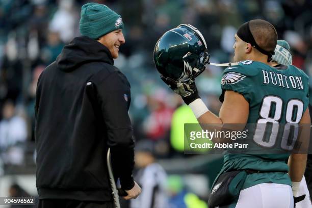 Injured Carson Wentz of the Philadelphia Eagles talks with teammate Trey Burton prior to the NFC Divisional Playoff game against the Atlanta Falcons...