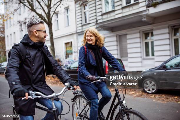 友人が冬の街をサイクリングに笑みを浮かべてください。 - winter cycling ストックフォトと画像