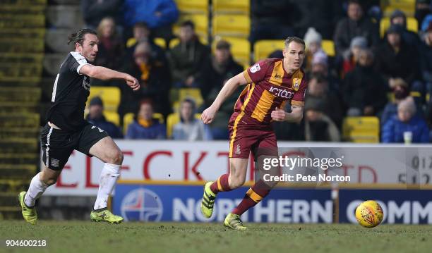 Matthew Kilgallon of Bradford City moves forward with the ball away from John-Joe O'Toole of Northampton Town during the Sky Bet League One match...