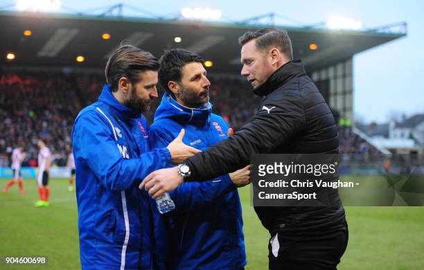 Lincoln City's assistant manager Nicky Cowley, left, and Lincoln City manager Danny Cowley, centre, shake hands with Notts County manager Kevin Nolan...