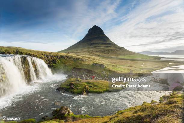 man standing below kirkjufell, iceland - snaefellsnes imagens e fotografias de stock