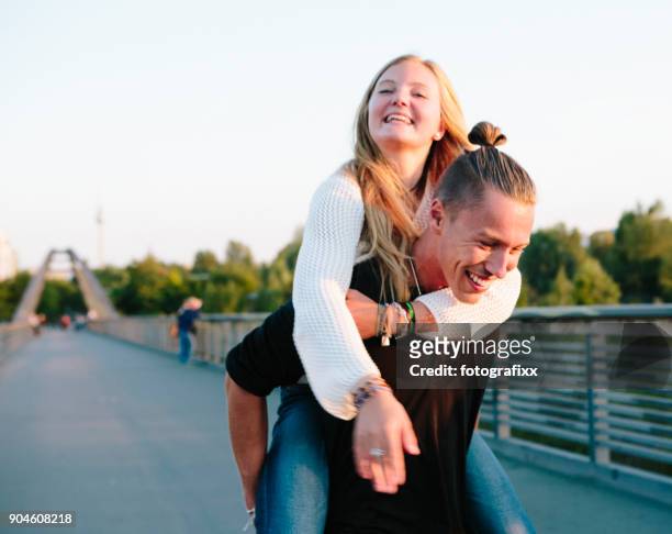 friendship: young couple has fun with piggyback, summer in berlin - teenage couple stock pictures, royalty-free photos & images