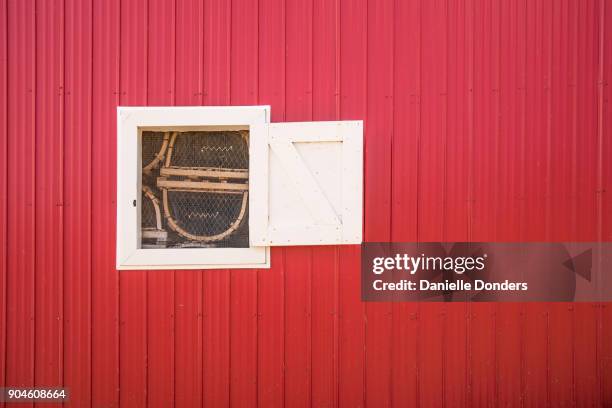 lobster traps through a window on a red shack - danielle donders stock pictures, royalty-free photos & images