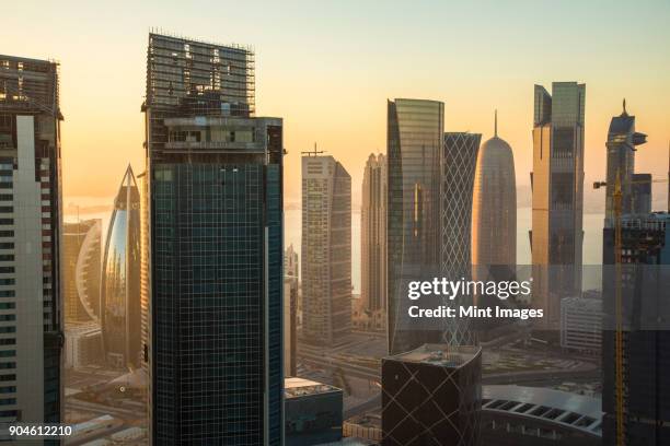 cityscape with tall modern skyscrapers at dusk. - doha skyscraper stock pictures, royalty-free photos & images