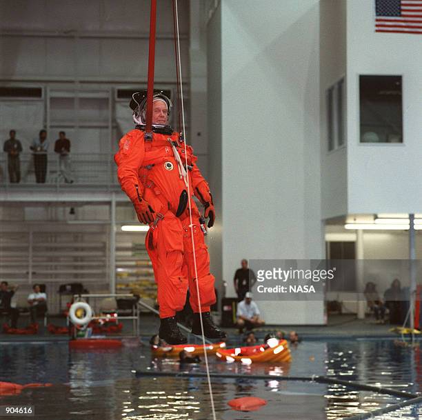 Senator John H. Glenn , simulates a parachute drop into water during emergency bailout training at the Sonny Carter Training Center April 12, 1998....