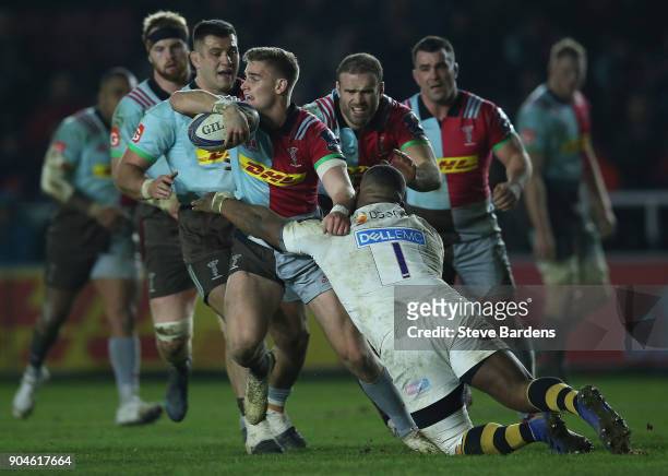 James Lang of Harlequins gets the ball away as he is tackled by Simon McIntyre of Wasps during the European Rugby Champions Cup match between...
