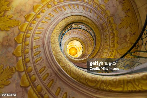 low angle view of spiral staircase decorated with murals of golden acanthus flowers and ornamental borders. - bear's breeches stock pictures, royalty-free photos & images