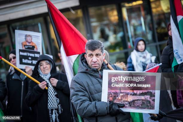 Man seen holding a placard during the protest. Demonstration of protest against the decision of Donald Trump, in violation of the international...