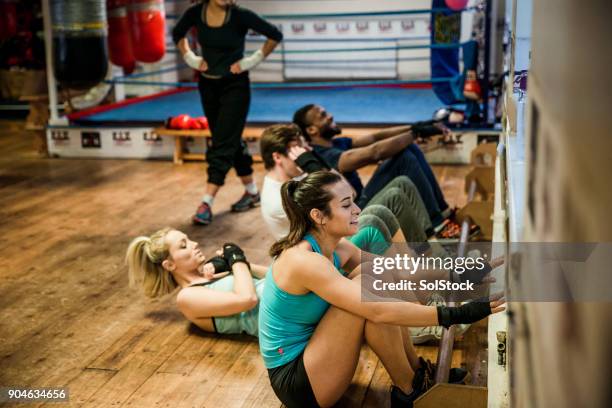 sit-ups during a circuit training class - circuit training stock pictures, royalty-free photos & images