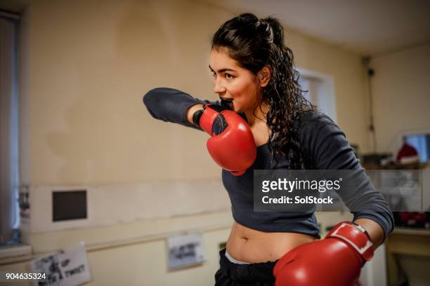 fit female putting on her boxing gloves - boxing womens stock pictures, royalty-free photos & images