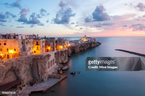 high angle view of traditional houses build on a cliff on the mediterranean sea at sunset. - puglia italy stock pictures, royalty-free photos & images