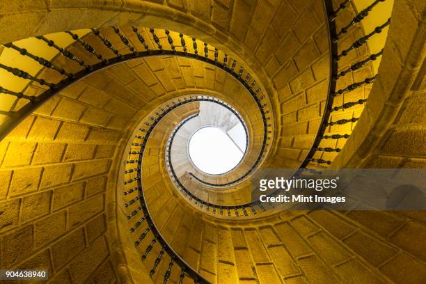 low angle view of stone spiral staircase towards skylight. - santiago de compostela spain stock-fotos und bilder