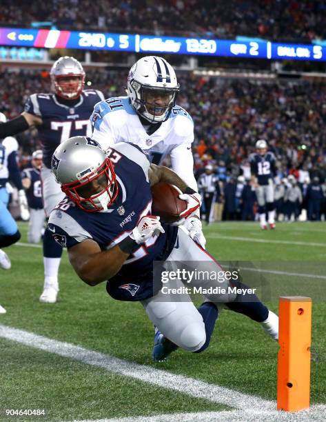 James White of the New England Patriots carries the ball for a touchdown as he is defended by Kevin Byard of the Tennessee Titans in the first...