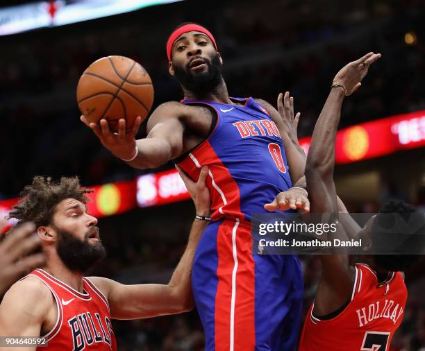 Andre Drummond of the Detroit Pistons rebounds between Robin Lopez and Justin Holiday of the Chicago Bulls at the United Center on January 13, 2018...