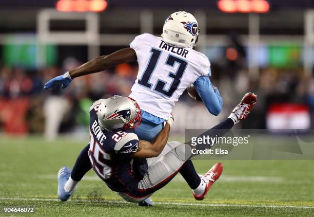 Taywan Taylor of the Tennessee Titans is tackled by Eric Rowe of the New England Patriots in the second quarter of the AFC Divisional Playoff game at...