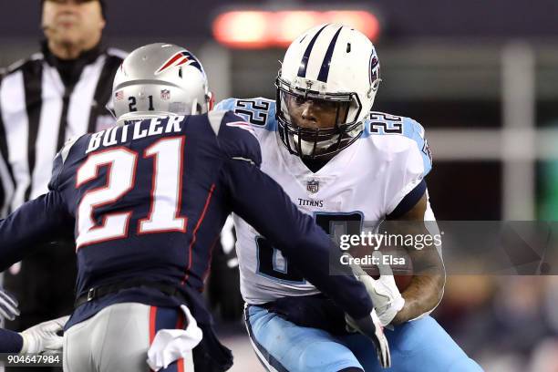Derrick Henry of the Tennessee Titans carries the ball as he is defended by Malcolm Butler of the New England Patriots in the second quarter of the...