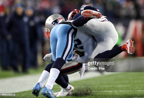 Patrick Chung of the New England Patriots tackles Adoree' Jackson of the Tennessee Titans in the second quarter of the AFC Divisional Playoff game at...