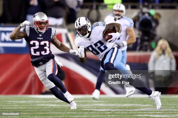 Delanie Walker of the Tennessee Titans carries the ball after catching a pass as he is defended by Patrick Chung of the New England Patriots in the...
