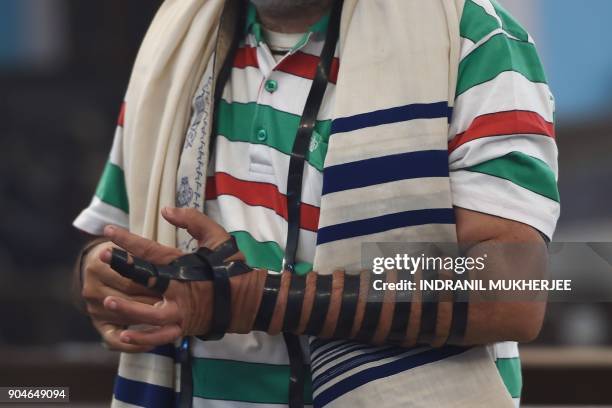 In this photo taken on January 9 a member of the Indian Jewish community binds the tefillin on his hand before a morning prayer service at the Magen...