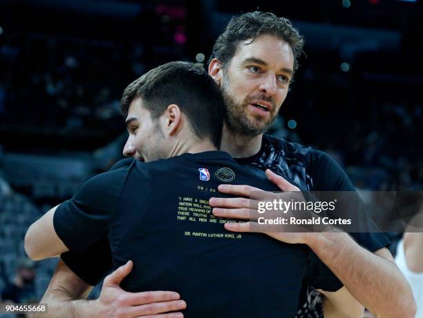 Pau Gasol of the San Antonio Spurs facing camera hugs Juan Hernangomez of the Denver Nuggets before the start of the game at AT&T Center on January...