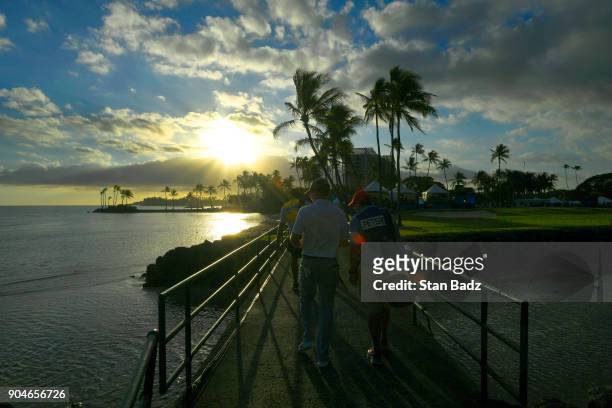Players approach the 17th green at sunset during the third round of the Sony Open in Hawaii at Waialae Country Club on January 13, 2018 in Honolulu,...