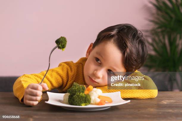 child is very unhappy with having to eat vegetables. - unpleasant taste stock pictures, royalty-free photos & images