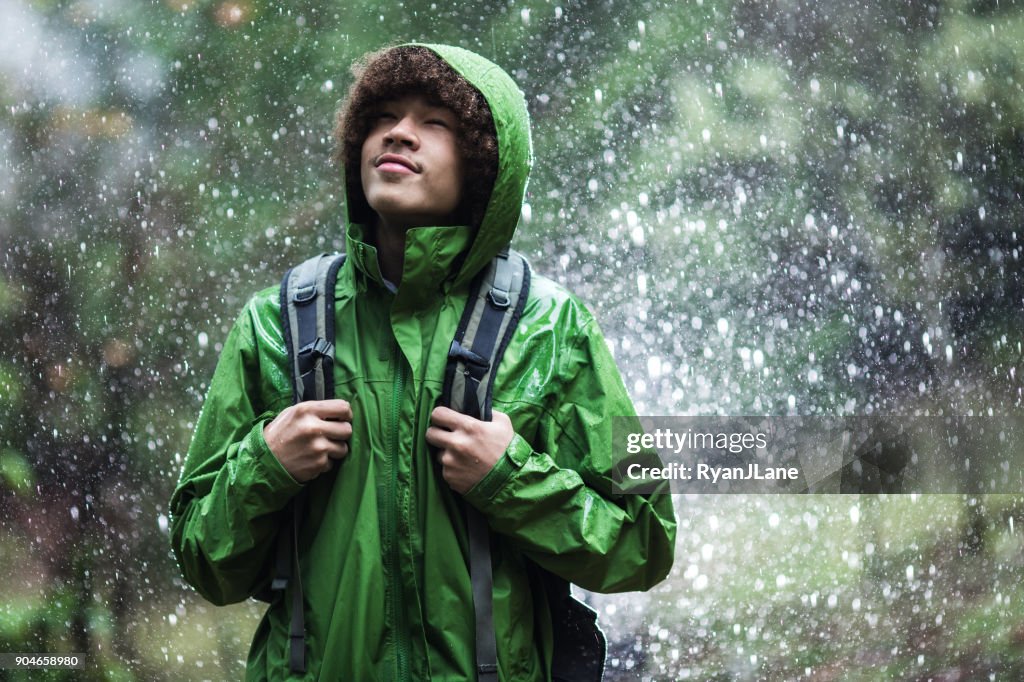 Young Man Hiking in Rain with Waterproof Jacket