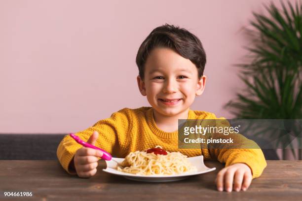 kind is spaghetti eten. - fat boys stockfoto's en -beelden
