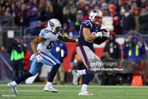 Rob Gronkowski of the New England Patriots catches a pass as he is defended by Wesley Woodward of the Tennessee Titans during the fourth quarter in...